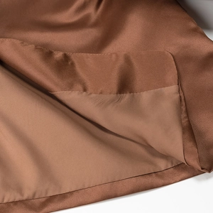 Detail of premium brown satin fabric showing professional edge stitching and silky texture