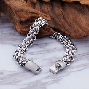 Detail of silver multi-layer woven chain bracelet with magnetic clasp on marble base