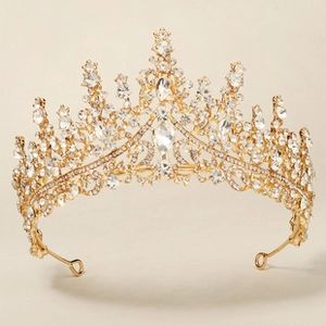 Detailed macro view of the gold tiara showing intricate rhinestones and pear-cut crystal