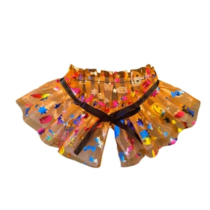 Detailed view of orange Halloween pet tutu with pumpkin prints and black satin bow