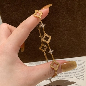 Detail view of gold-plated clover bracelet with zircon pavé on a model hand