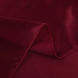 Macro shot of dark red satin fabric showing high-density stitching and twill texture details