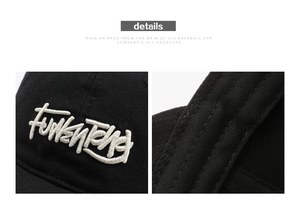 Detail showing white 3D letter embroidery and double stitching on black cotton baseball cap