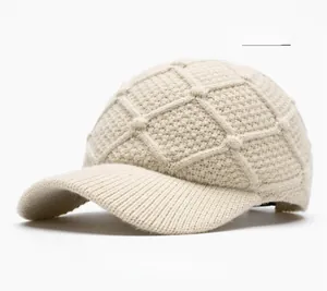 Detail of beige knitted baseball cap with textured diamond pattern and warm ribbed brim