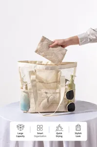 Detail van mesh strandtas met buitenvakken voor handdoeken en huidverzorging