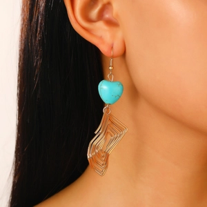 Detail of vintage bohemian turquoise earrings with heart stones and gold leaf tassels