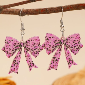 Close-up van roze strikoorbellen met luipaardprint hangend aan een houten tak