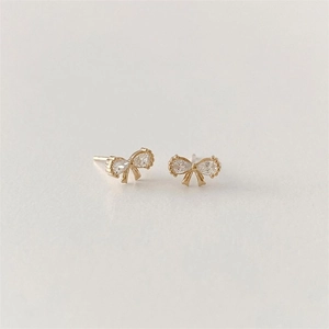 Detailed close-up of bow knot stud earrings featuring teardrop zircon in gold finish