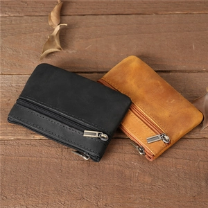 Vue de dessus de deux porte-monnaie en cuir vintage noir et marron sur bois rustique