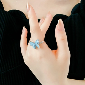 Λεπτομέρεια δαχτυλιδιού πεταλούδα με γαλάζιο κρύσταλλο στο δάχτυλο ενός ατόμου