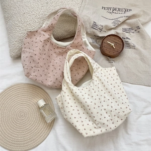 Floral corduroy handbags in pink and beige displayed with aesthetic home decor items