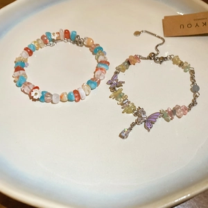 Detail of colorful crystal bead bracelet with daisy and purple butterfly pendant