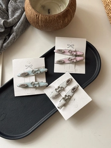 Close-up of three cute enamel Scottie dog hair clips with rhinestones in pink, blue, and grey