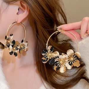Close-up of golden hoop earrings featuring three 3D leopard print fabric flowers