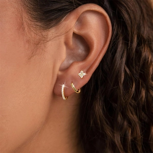 Detail shot of s925 silver gold earring set featuring floral studs and hoop earrings
