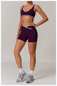 Detail of cross high-waist yoga shorts and matching sports bra with white contrast trim