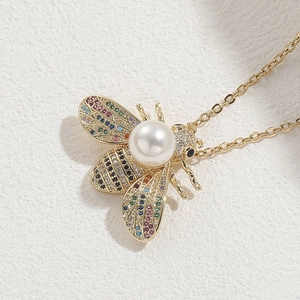 Pendente ape placcato oro 14K con zirconi colorati e perla su sfondo bianco
