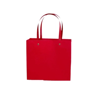 Elegant red gift paper bag with flat handles and gold rivet details on white background