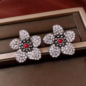 Macro shot of silver vintage flower earrings with red centerpiece and sparkling zircons