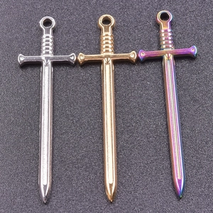 Detailed view of three sword pendants in silver, gold, and rainbow vacuum plated steel