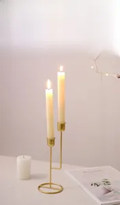 Close-up of asymmetric double-head gold metal candle holder with elegant ring base