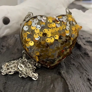Detailed macro of a heart-shaped evening bag with shiny gold and silver sequins