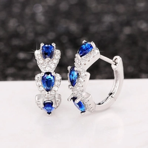 Close-up of Klein blue zircon hoop earrings with pear-shaped stones and silver plating