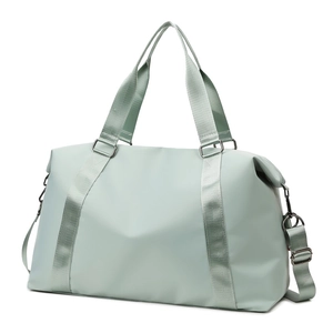 Detail of mint green waterproof travel bag showing detachable woven shoulder strap