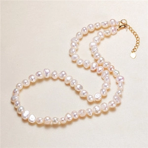 Detailed view of natural baroque pearl necklace with gold plated lobster clasp and chain