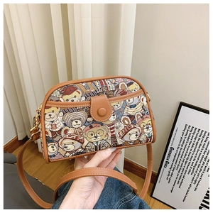 Detail of vintage bear jacquard fabric and brown leather strap on a crossbody bag