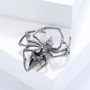 Detailed shot of dark silver spider brooch with a polished black gemstone inlay
