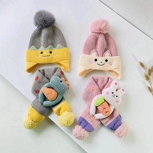 Detail of children's knit hat and scarf set featuring cute cartoon dinosaur and rabbit themes