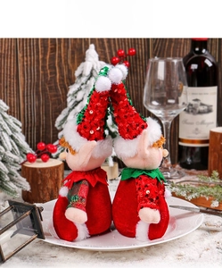 Close-up of Christmas elf figurines with sequin hats in a festive winter table display