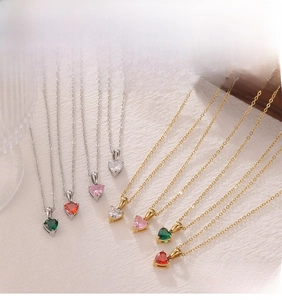 Close-up of heart-shaped zircon pendants on gold and silver chains in various colors
