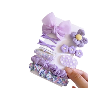 Purple floral fabric bow hair clip and scrunchie set displayed on a card holder