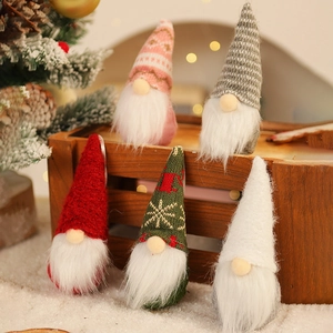Close-up of five knitted Christmas gnomes with snowflake patterns on festive tree branches
