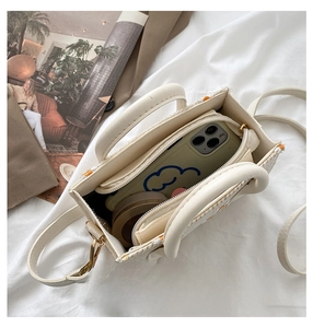 Macro view of woven daisy tote interior capacity with phone and cosmetics