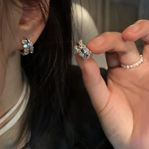 Elegant gold plated leaf earring with sparkling zircons worn for a luxury fashion look