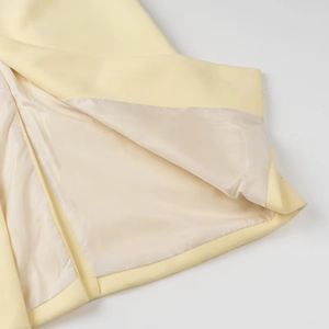 Close-up of the satin lining and high-quality stitching on this yellow wool coat