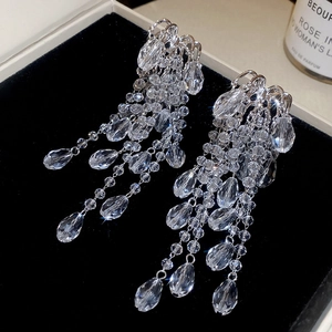 Detailed macro view of cascading teardrop crystal tassels on silver luxury earrings