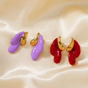 Unique colorful drop-shaped earrings in red and purple on a soft beige silk background