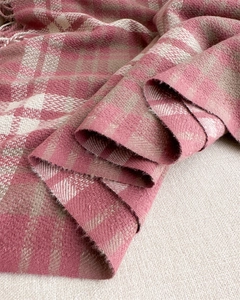 Close-up of soft plaid scarf showing thick pink cashmere texture and long fringe tassels