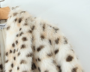 Detailaufnahme der weichen Kunstpelz-Textur mit Leopardenmuster und Kragenetikett