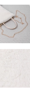 Detail of plush faux fur texture and elegant gold metal chain strap on off-white bag