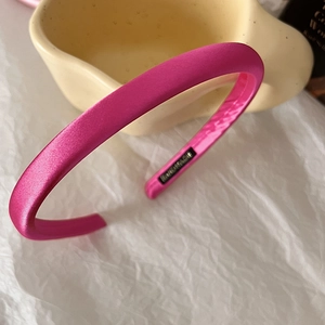 Detail shot of a hot pink satin padded headband with premium glossy fabric texture