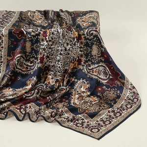 Close-up of paisley floral pattern on large silk satin square scarf with draped texture