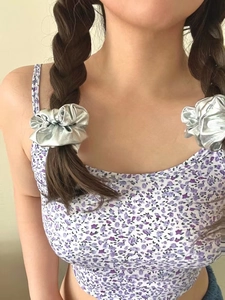 Silver metallic scrunchie tied on a braided ponytail with reflective pleated texture