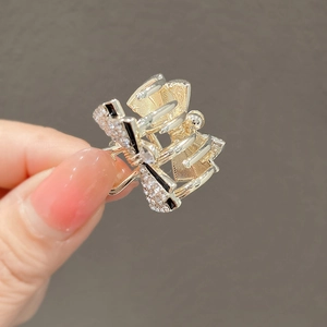 Exquisite golden bow hair claw clip with black accents and sparkling rhinestones