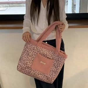 Detail of pink leopard print tote bag with plush fleece pocket and shoulder strap