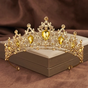 Macro view of golden Baroque bridal crown with amber rhinestones on a jewelry box